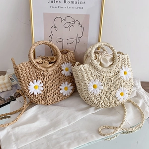 Detailansicht von handgeflochtenen Strohtaschen mit Gänseblümchen und Kordelzug