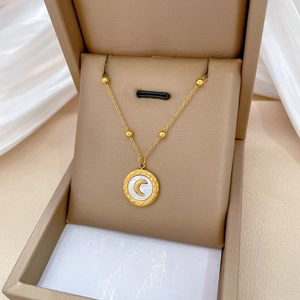 Titanium steel gold necklace with shell moon pendant shown in a jewelry box