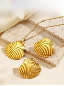 Detail of gold shell jewelry set on stone and silk background showing textures