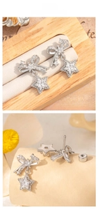 Close-up of bowknot and star pendant earrings with zircon inlays on a warm background