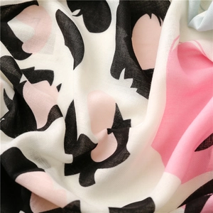 Detailed close-up of tropical floral print on soft cotton-linen fabric with fringe details