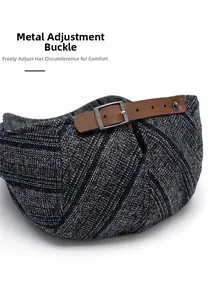 Detail of adjustable brown leather strap and silver buckle on a tweed flat cap