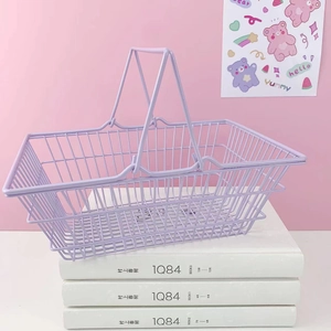 Detail of purple wire mesh storage basket with double handles on a stack of books