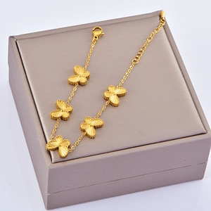 Detail of gold butterfly bracelet featuring 5 hammered pendants and a lobster clasp