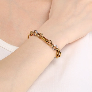 Detailed view of fashion gold and silver steel chain bracelet worn on a woman wrist