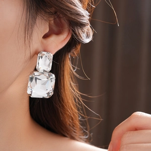 Macro di orecchini con cristalli quadrati su modella per accessori da abito elegante