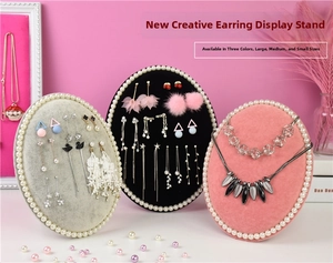 Detail of velvet earring display stands with pearl borders in pink, black and grey tones