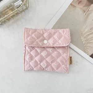 Detailed view of pink quilted heart fabric storage bag with a white snap button closure