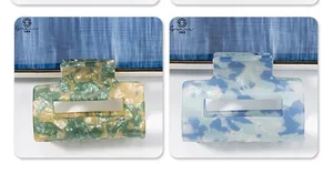 Detailed macro view of square acetate hair claws with premium marble texture patterns
