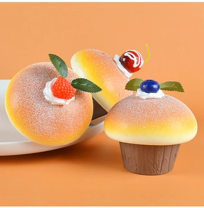 Close-up of artificial PU cupcakes with realistic blueberry, strawberry, and cherry toppings