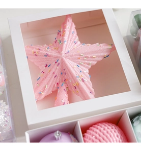 Pink macaron Christmas tree topper star with glitter in a white gift box packaging