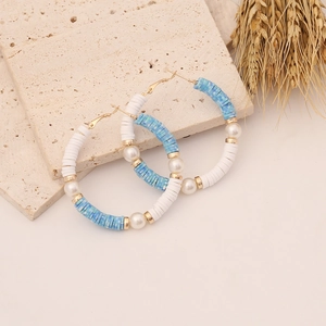 Detailed shot of Bohemian hoop earrings with blue and white clay beads and pearls