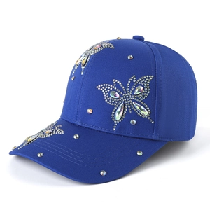 Detail of dark blue cotton baseball cap with sparkling butterfly rhinestone embellishment