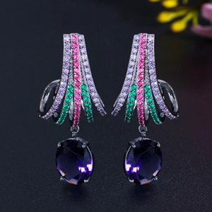 Detail of dark gold earrings featuring large purple zircon and colorful crystal inlay
