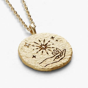 Golden stainless steel coin necklace with celestial sun and star patterns on white background