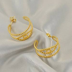 Three-layer gold hollow C-shaped earrings made of polished stainless steel on silk