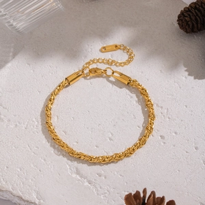 Détail du bracelet chaîne torsadée dorée 18 carats avec fermoir mousqueton sur pierre