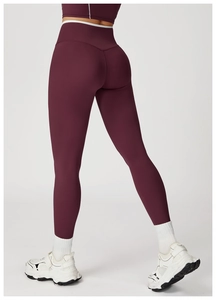 Detail van bordeauxrode yoga legging met hoge taille, V-naad en witte afwerking