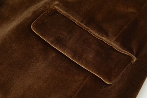 Macro detail of high-quality brown velvet fabric stitching and pocket flap on suit