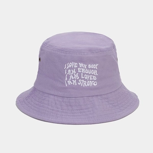 Vue détaillée du chapeau bob en toile lavande avec broderie de slogans positifs blancs