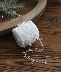 Close-up of iridescent crystal bead garland on a white spool for Christmas tree decoration