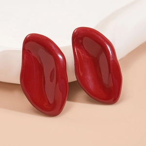 Detailed macro view of red enamel irregular oval stud earrings on white stone
