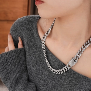 Macro shot of silver Cuban link necklace with sparkling crystals and large decorative buckle
