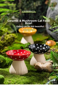 Detail of red mushroom-shaped ceramic cat bowl with white dots and elevated base