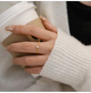 Detailed view of twisted gold rope ring with oval zircon on a lifestyle hand model