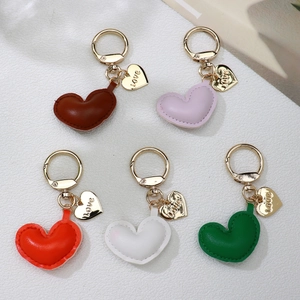 Five assorted colors of leather heart keychains with gold love charms and spring rings