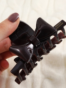 Detailed close-up of a large black bow hair claw clip with France Handmade gold lettering