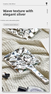 Detailed macro view of the silver wavy texture on this portable handheld makeup mirror