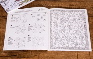 Detail showing step-by-step hand-drawing guide on open pages of coloring book