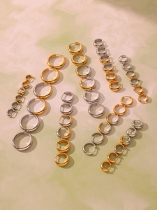 Macro view of two-tone stainless steel hoop earrings in various sizes and finishes