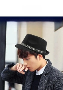 Close-up of black fedora wool hat featuring a vintage leather belt with silver rivets