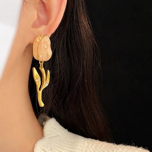 Vintage tulip drop earrings with orange glaze, pearls, and gold-plated zircons on model
