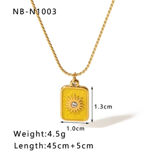 Detail of gold rectangular pendant with yellow enamel starburst and cubic zirconia stone