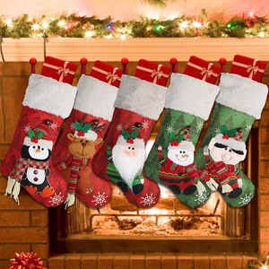Five assorted Christmas stockings with plush cuffs hanging on a festive mantelpiece