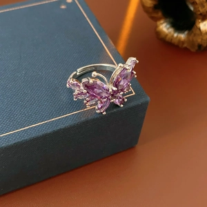 Détail macro de la bague papillon en argent avec zircons violets sur un coffret à bijoux