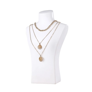 Three-layer gold necklace set featuring tree of life and map charms on a bust display