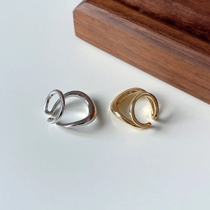Macro shot of S925 hallmark on minimalist irregular double-row silver and gold ear cuffs