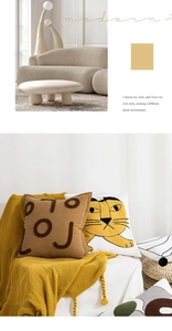 Modern embroidered throw pillows with abstract letters and cat pattern on a beige sofa