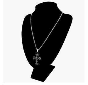 Macro view of silver stainless steel box chain with a skull cross pendant on a black mannequin