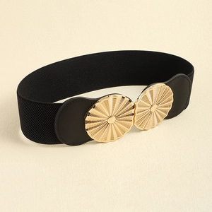 Detail of black elastic waist belt featuring a textured gold circular metal buckle