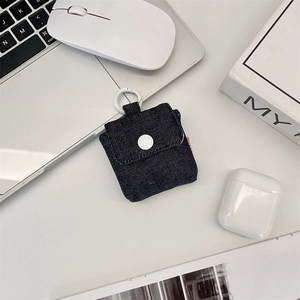 Detail of mini denim earphone case with white button closure and round carabiner hook
