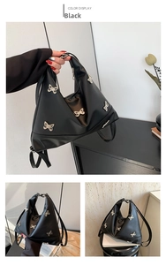 Detail of black PU leather bag with five silver metal butterflies and zipper closure
