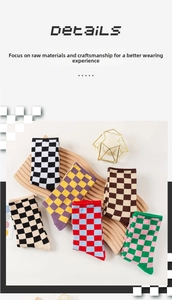 Detailed view of colorful checkerboard knit mid-calf socks on a wooden tray display