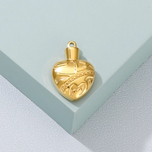 Vintage heart-shaped gold stainless steel locket pendant with embossed textures on blue block