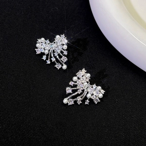 Macro detail of vintage butterfly earrings featuring sparkling crystals and white pearls