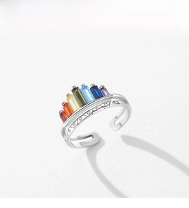 Macro shot of silver rainbow crown ring with colorful gradient baguette gemstones